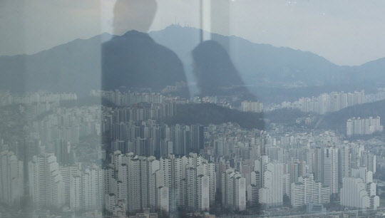 서울 63빌딩 유리에 한 커플과 일대 아파트가 비쳐 보인다. <연합뉴스>